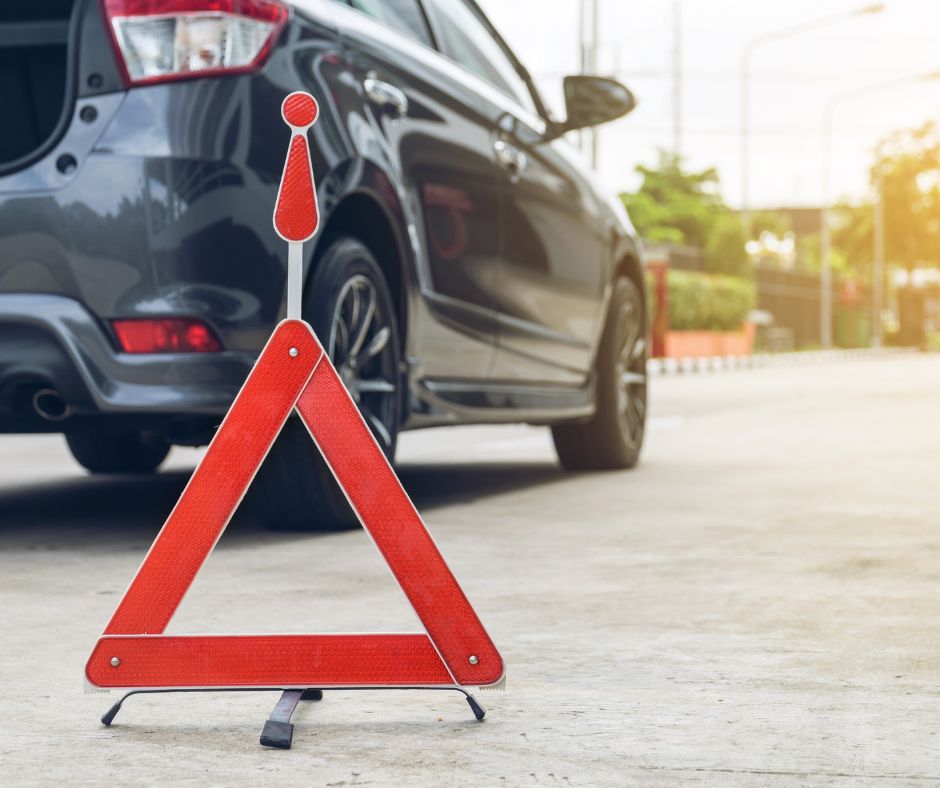 Imagem de triângulo de sinalização de perigo com carro por detrás